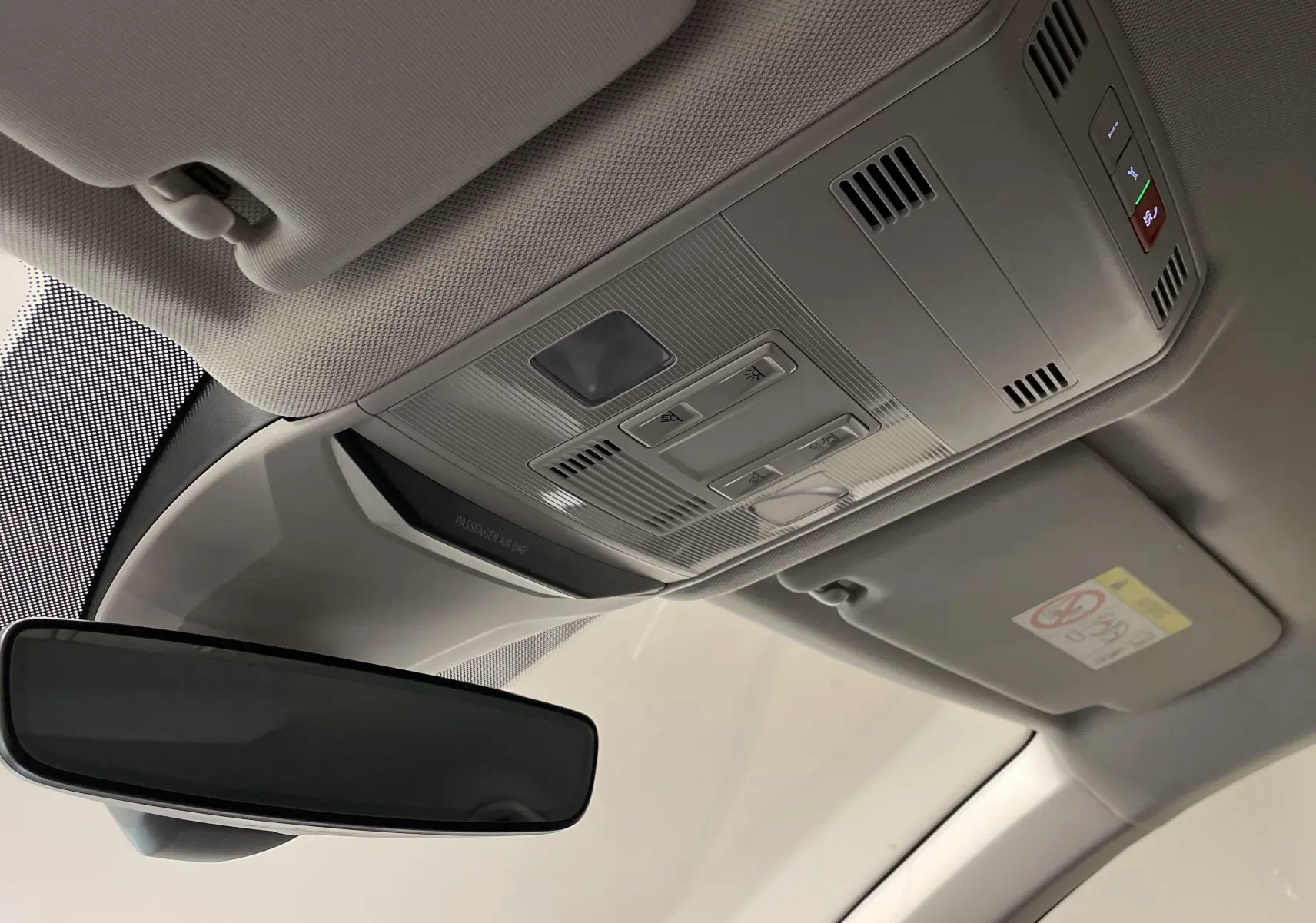 Vue intérieure du rétroviseur et plafonnier du Volkswagen T-Roc 2024 avec commandes intégrées et finition claire.