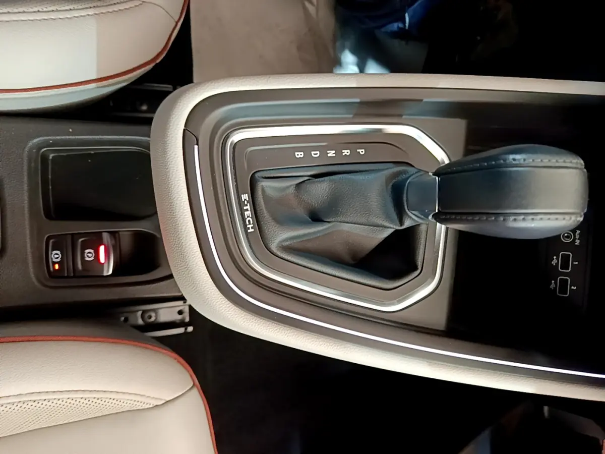 Gros plan sur la console centrale beige avec levier de vitesse automatique noir marqué E-TECH dans une Renault Clio Initiale Paris.