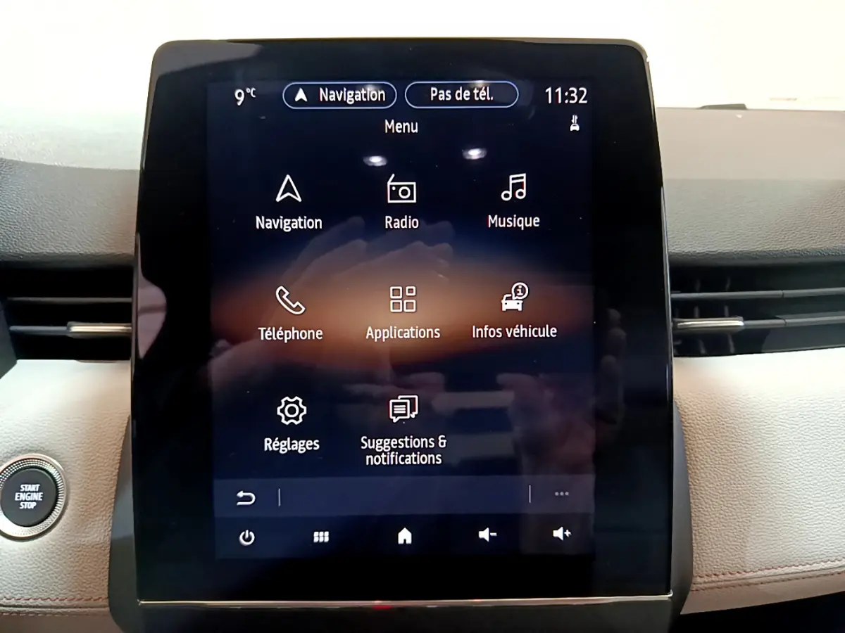 Écran tactile central de la Renault Clio Initiale Paris orange 2021 affichant le menu multimédia avec bouton démarrage visible à gauche