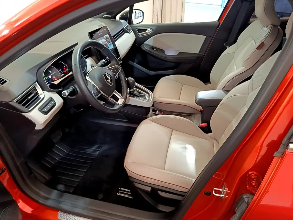 Intérieur avant droit de la Renault Clio Initiale Paris orange 2021 avec sièges cuir beige et écran tactile vertical.