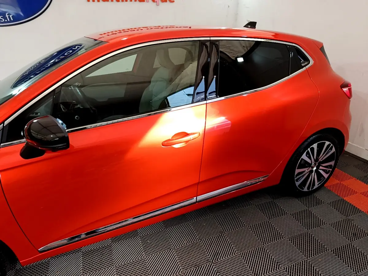 Profil côté gauche de la Renault Clio Initiale Paris orange 2021 avec jantes alliage et rétroviseur noir brillant