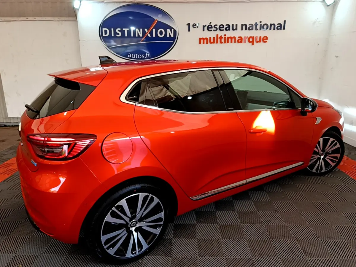Renault Clio Initiale Paris E-TECH 140 orange vue de profil côté droit, avec jantes alliage et vitres teintées.