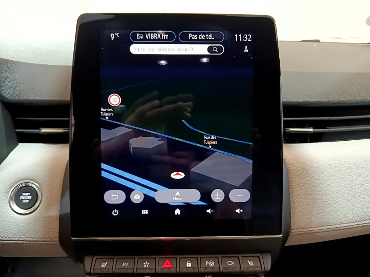 Écran tactile central du tableau de bord de la Renault Clio Initiale Paris orange, avec navigation 3D affichée.