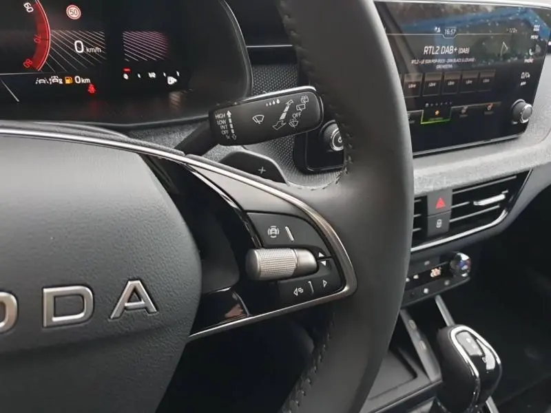 Vue intérieure du tableau de bord et console centrale du Skoda Kamiq 2025 gris Diamant, avec écran tactile et levier de boîte automatique.