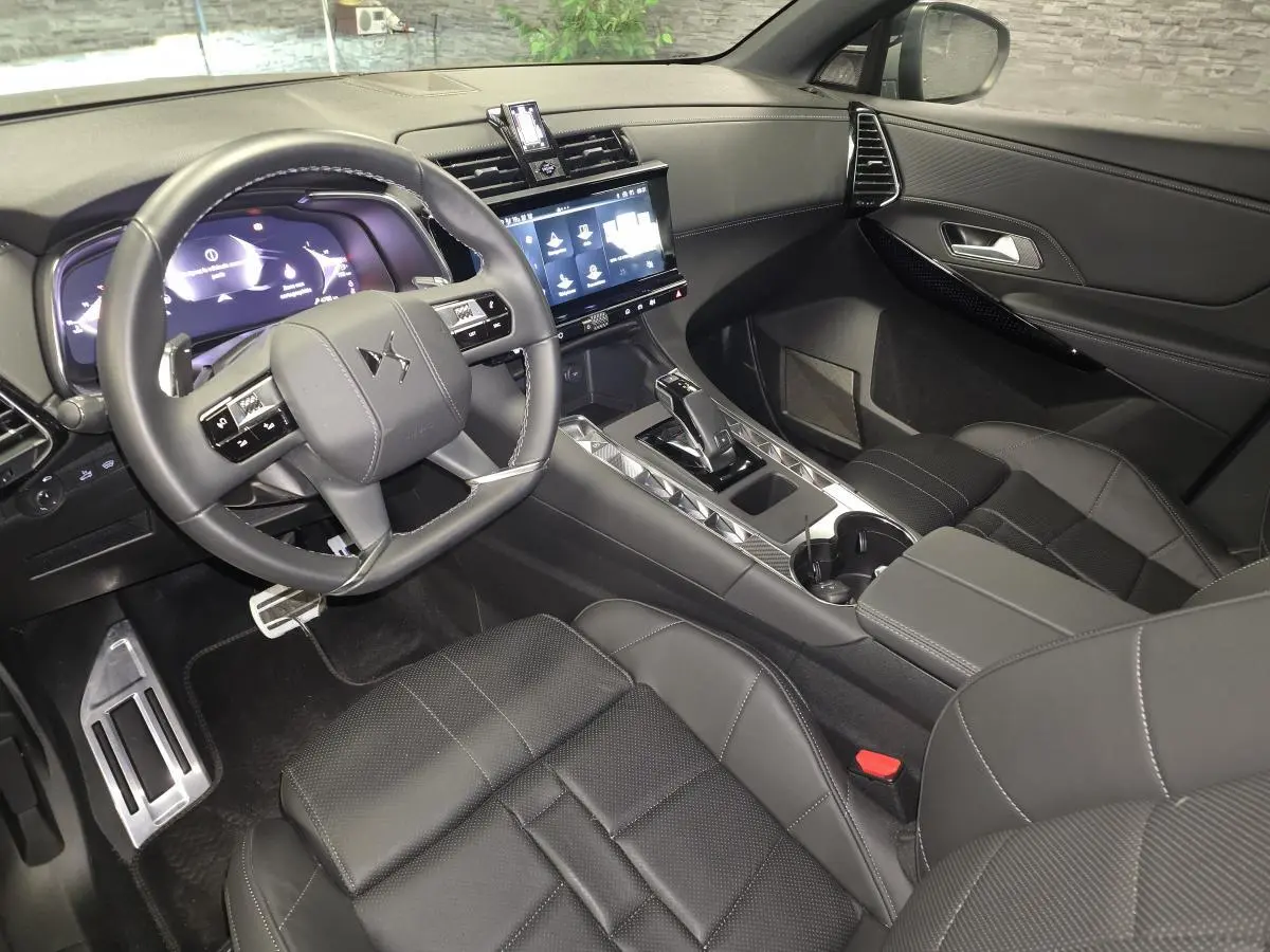 Vue intérieure côté conducteur du DS7 Crossback 2025 en cuir noir avec écran tactile et volant multifonction.