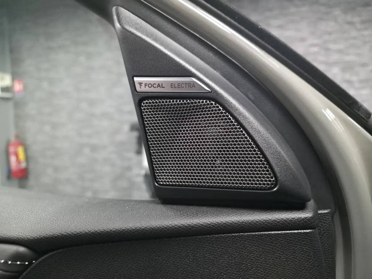 Gros plan sur le haut de la porte avant gauche du DS7 Crossback gris, mettant en valeur l'enceinte FOCAL Electra intégrée.