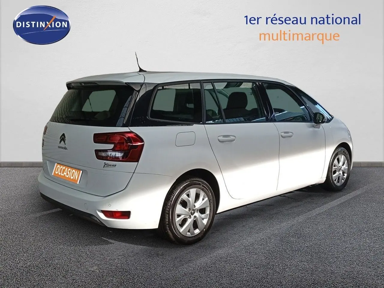 Vue 3/4 arrière droite d'un Citroën Grand C4 Picasso blanc avec vitres teintées et jantes alliage.