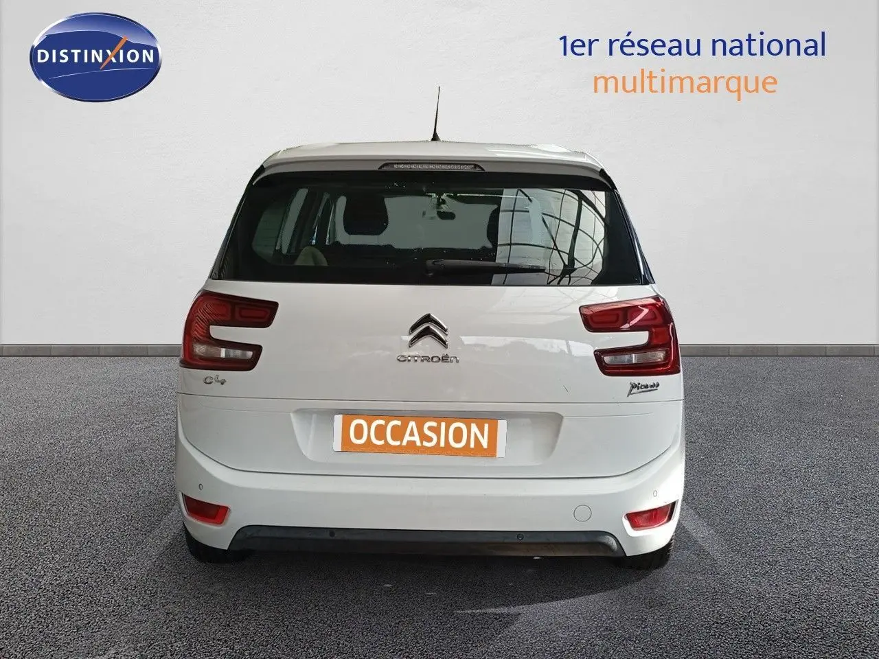Vue arrière d'un Citroën Grand C4 Picasso blanc de 2016 avec feux arrière distinctifs et plaque "OCCASION".