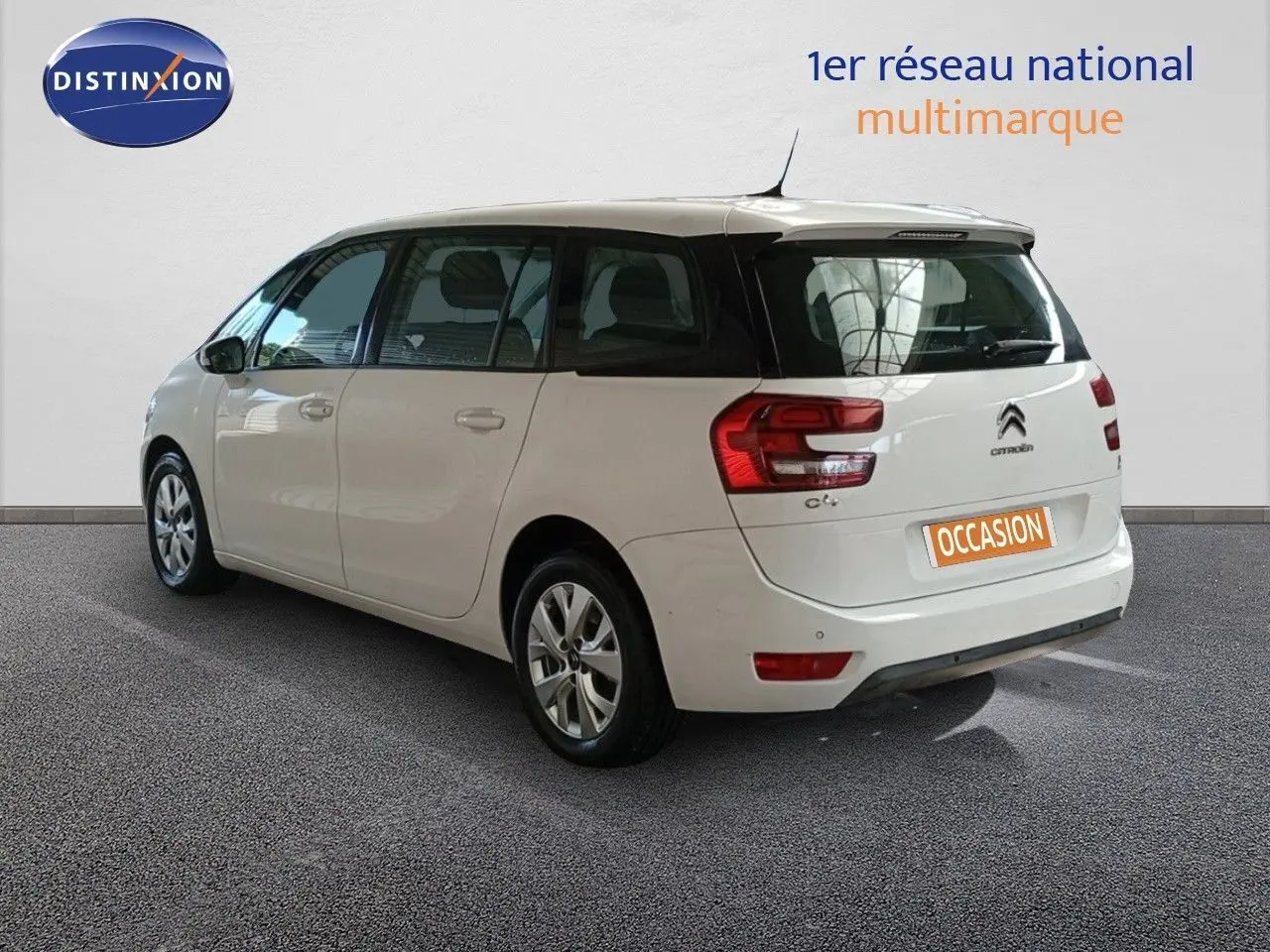 Vue 3/4 arrière gauche d'un Citroën Grand C4 Picasso blanc avec feux arrière distinctifs et cinq portes.