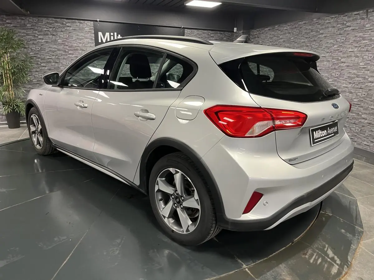 Vue 3/4 arrière droite d'une Ford Focus 1.0 EcoBoost gris lunaire avec jantes alliage et feux arrière LED.