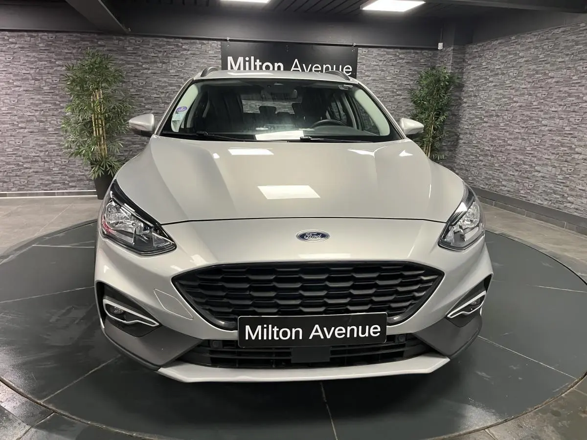 Vue avant d'une Ford Focus gris lunaire avec calandre noire et feux LED dans un showroom.