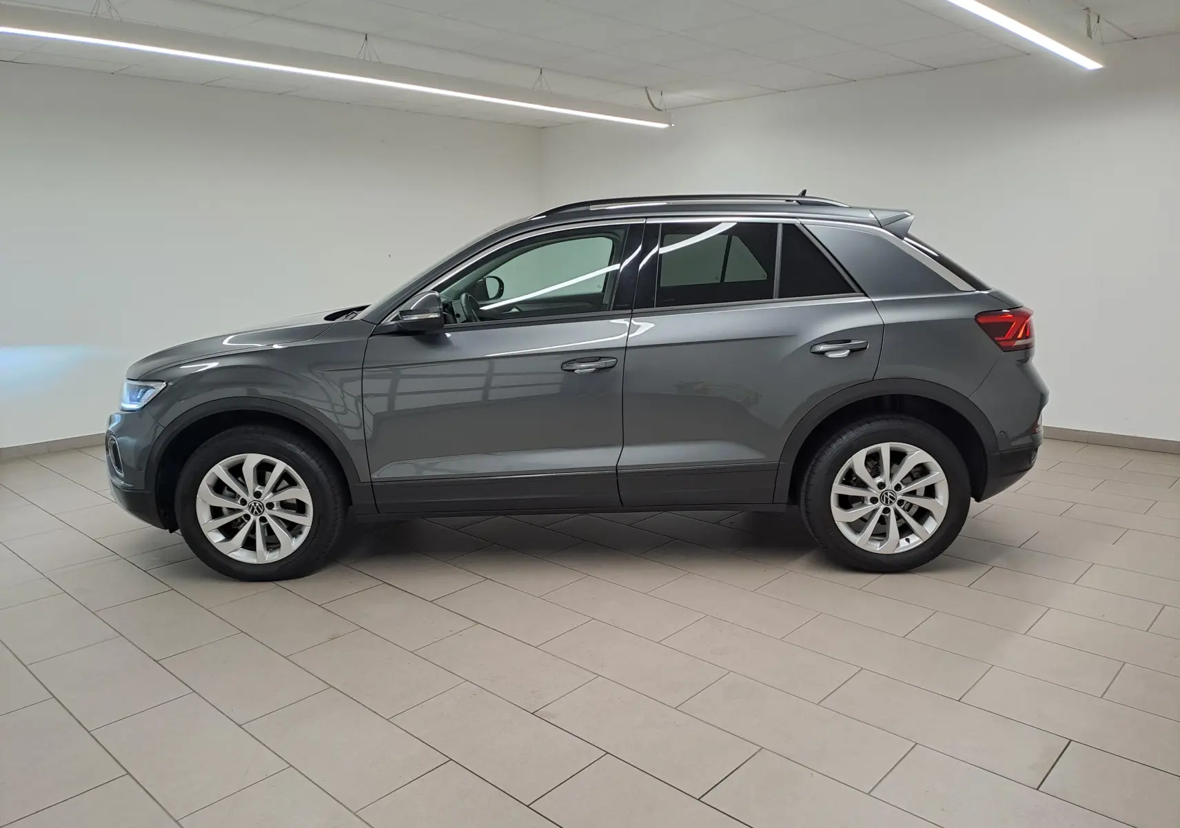 Profil droit du Volkswagen T-Roc 2024 gris Indium avec jantes alliage 17'' Johannesburg dans un intérieur neutre.