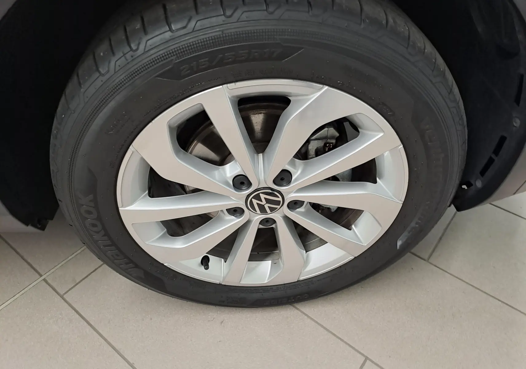 Gros plan sur la jante alliage 17'' Johannesburg avec logo Volkswagen du Volkswagen T-Roc Gris Indium 2024.