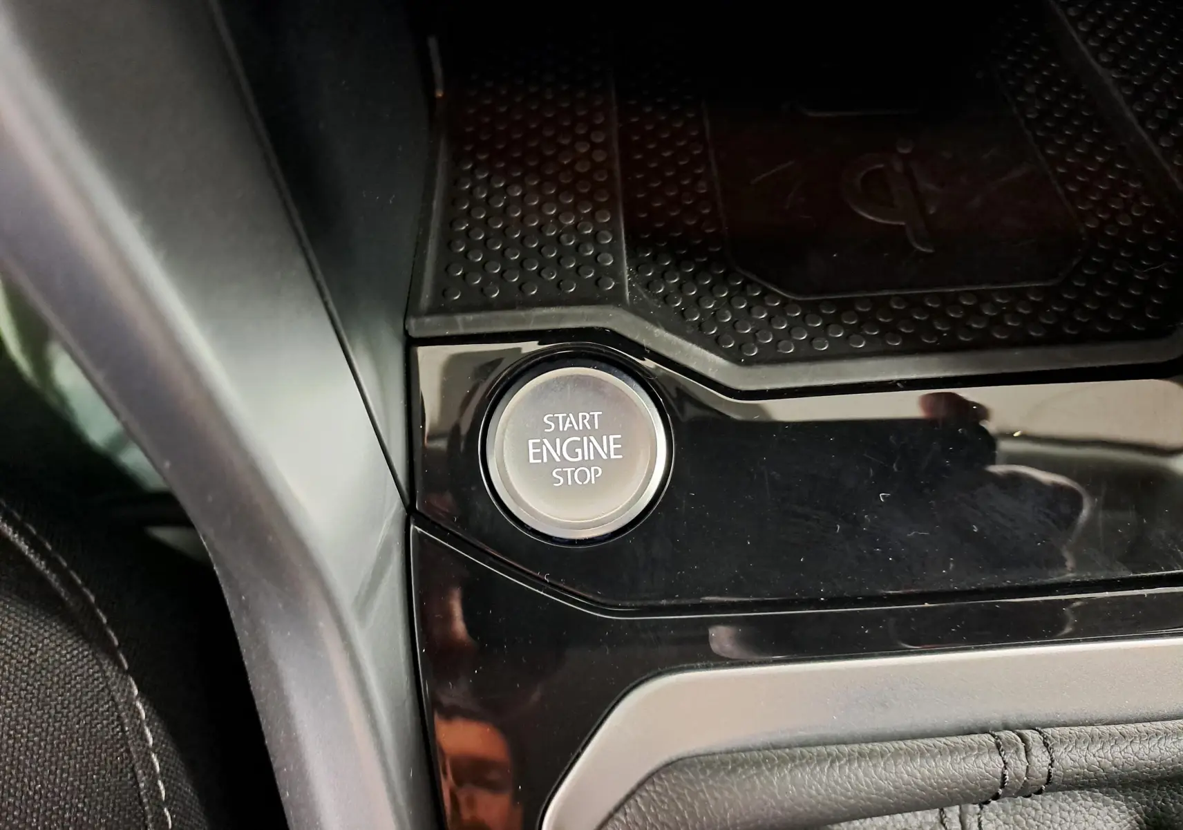 Bouton Start Engine Stop en gros plan sur la console centrale d'un Volkswagen T-Roc Gris Indium 2024.
