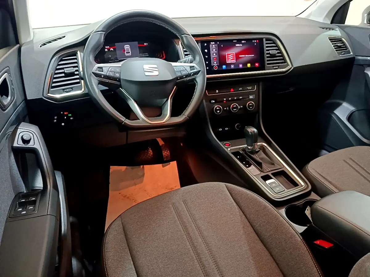 Intérieur du SEAT Ateca 2022 vu côté conducteur, volant cuir, écran tactile central et levier de boîte automatique.