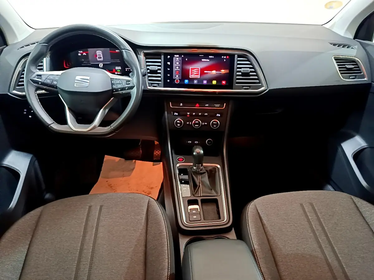 Intérieur de la SEAT Ateca 2022 vu de face, tableau de bord noir avec écran tactile central et volant multifonctions.