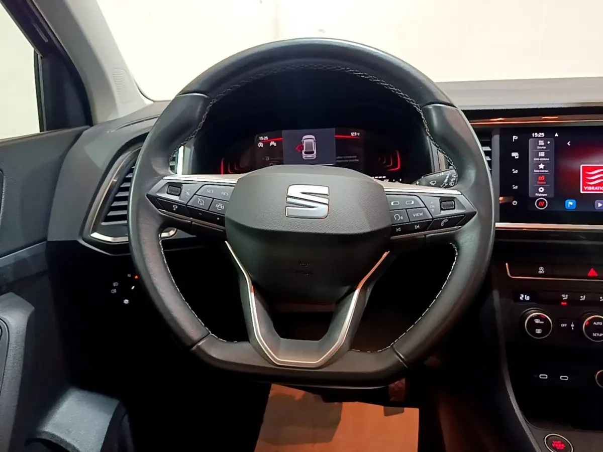 Volant cuir SEAT Ateca 2022 vu de face, avec commandes intégrées et tableau de bord numérique éclairé.