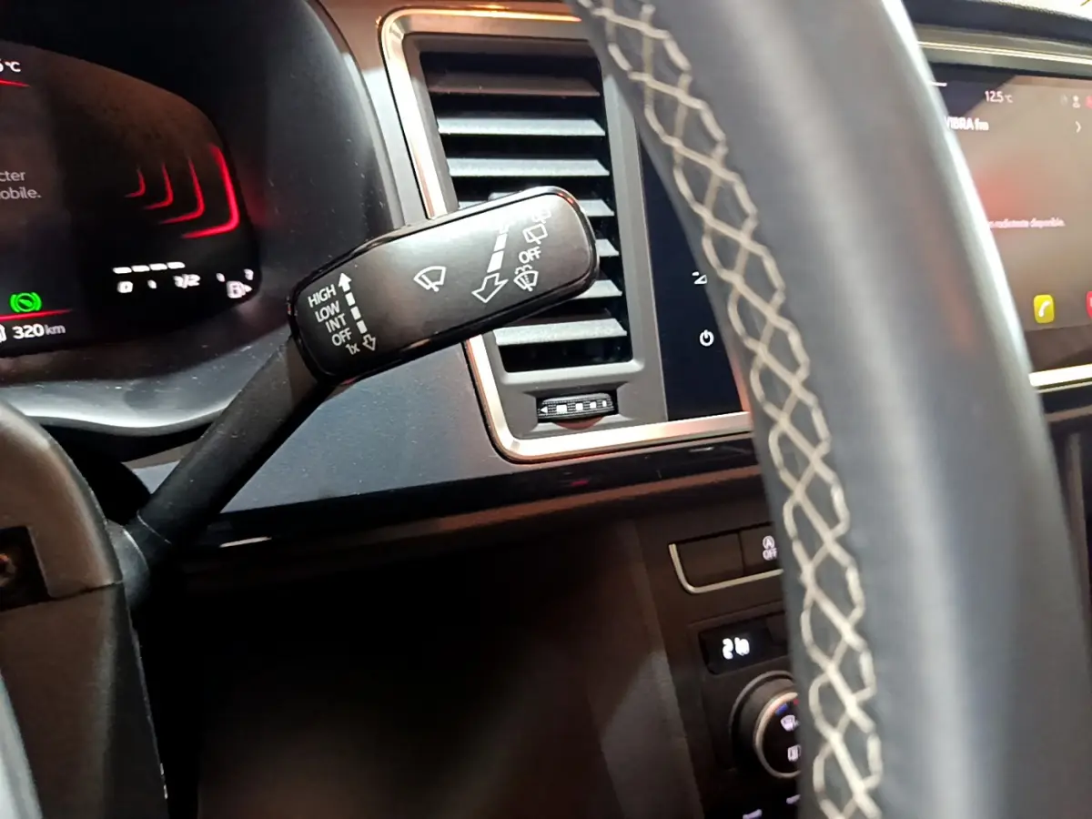 Détail du commodo d'essuie-glace côté gauche dans l'habitacle noir du SEAT Ateca 2022, avec tableau de bord et écran tactile visibles.