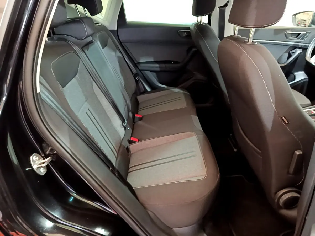 Vue intérieure côté gauche sur la banquette arrière tissu gris et noir du SEAT Ateca noir 2022 avec portes ouvertes.