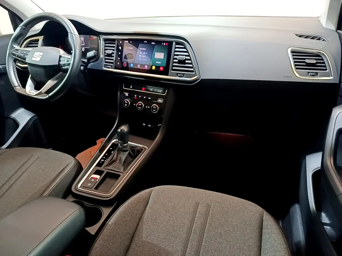 Vue intérieure côté conducteur du tableau de bord et console centrale du SEAT Ateca 2022 avec écran tactile et volant cuir noir.
