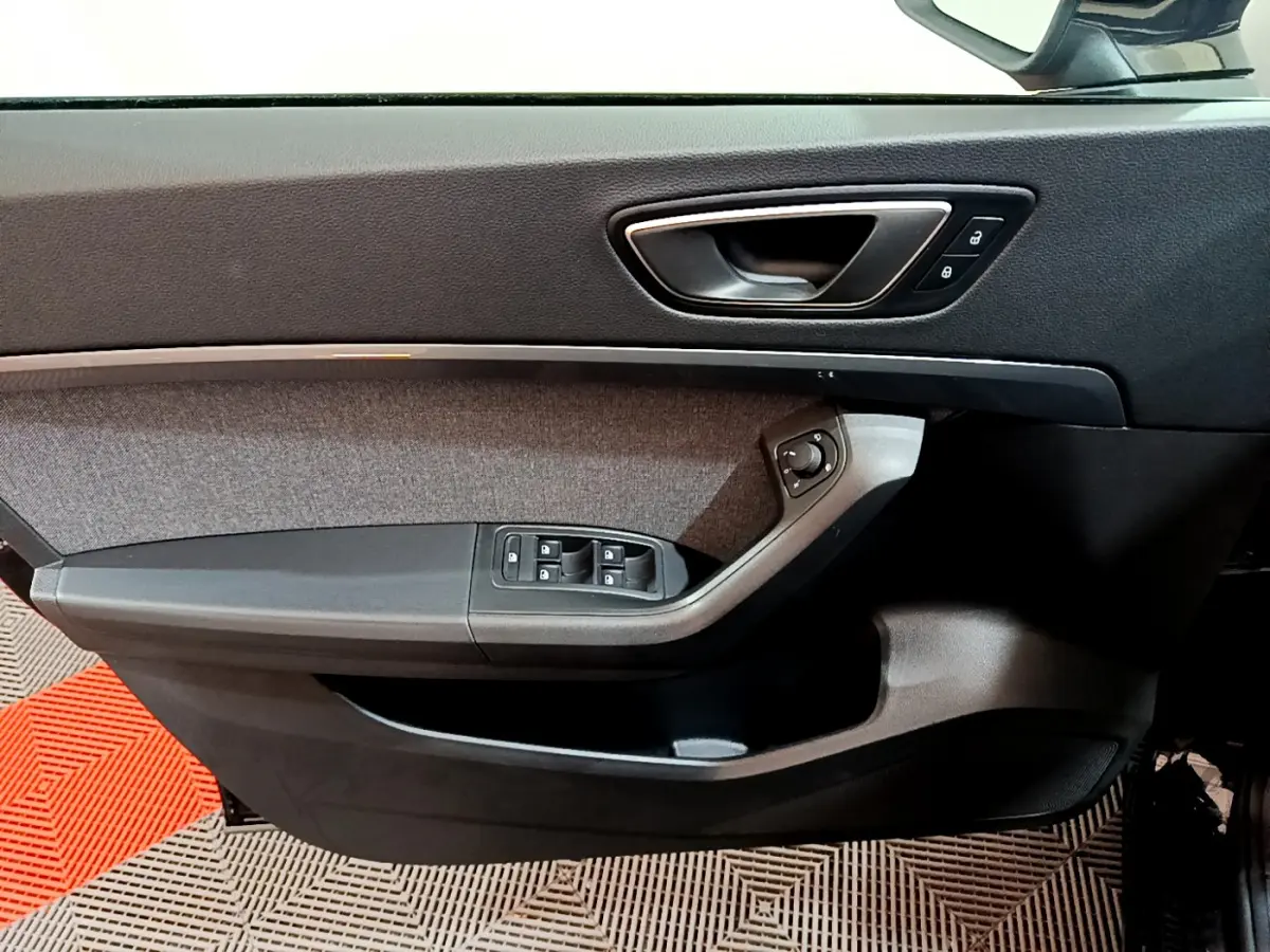 Intérieur côté gauche de la porte SEAT Ateca 2022 noire, avec commandes vitres et poignée argentée.