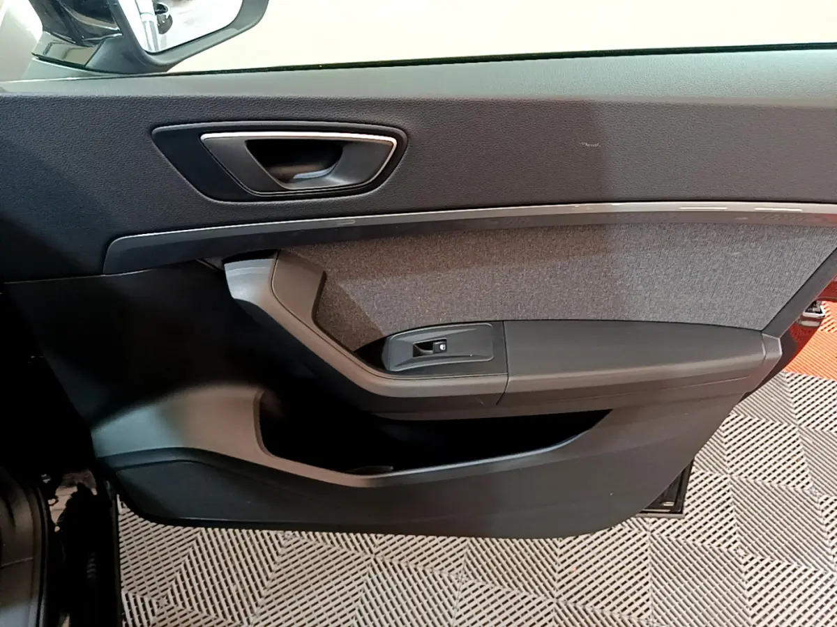 Gros plan sur la garniture intérieure de la porte avant gauche noire du SEAT Ateca 2022, avec insert tissu gris.