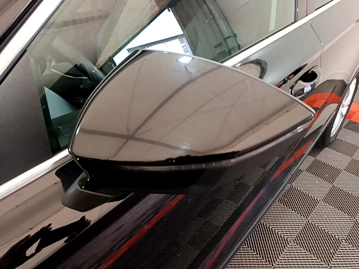 Rétroviseur côté gauche noir brillant du SEAT Ateca 2022, avec reflet du plafond et partie de la portière visible.