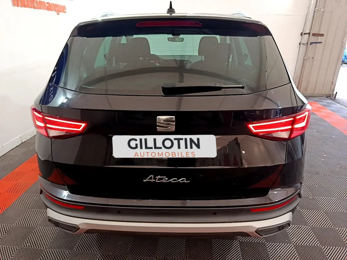 Vue arrière d'un SEAT Ateca noir avec feux LED allumés et logo visible sur un sol à damier rouge et gris.