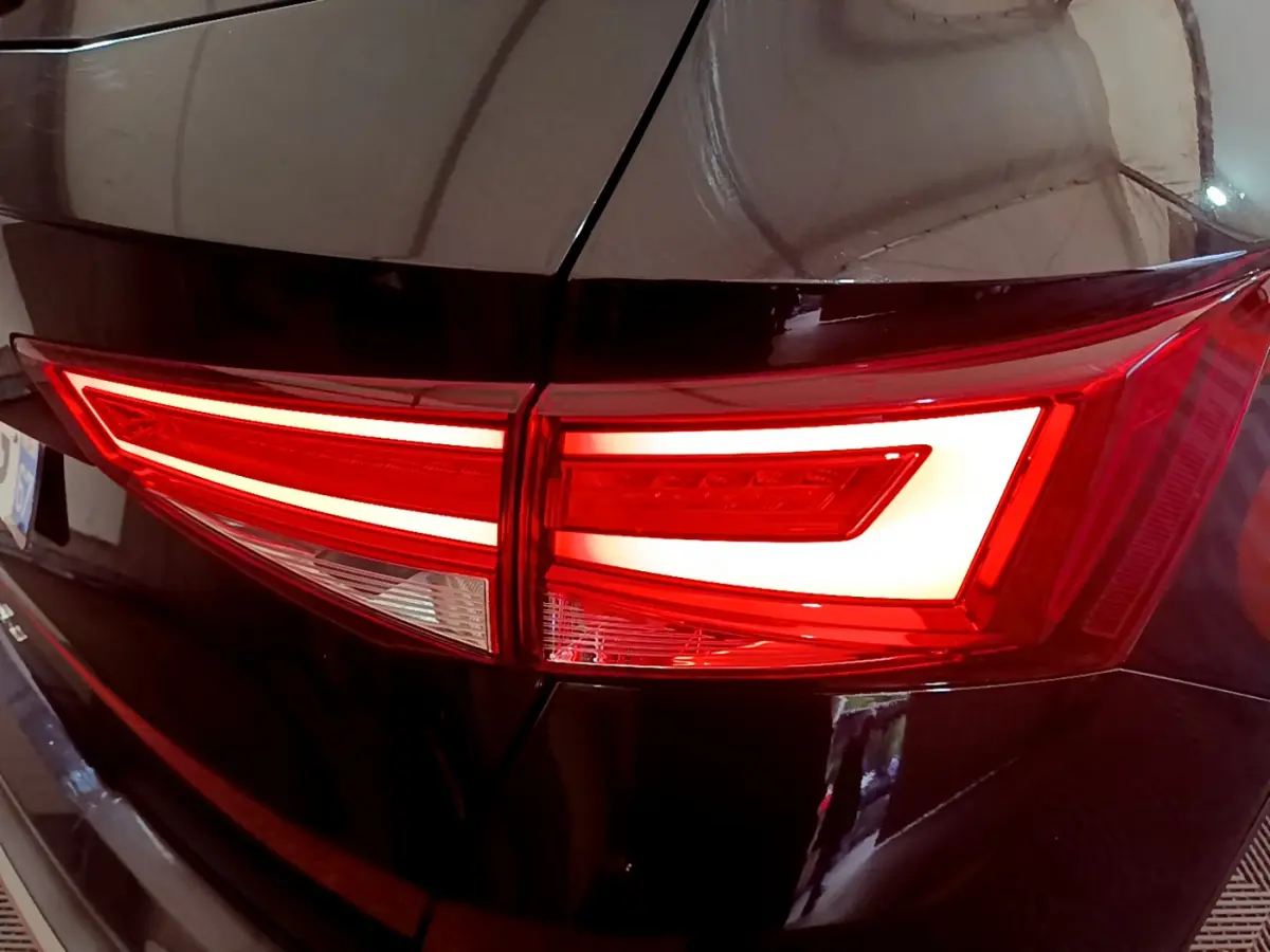 Gros plan sur le feu arrière droit allumé du SUV noir SEAT Ateca 2022 avec design lumineux distinctif en LED.