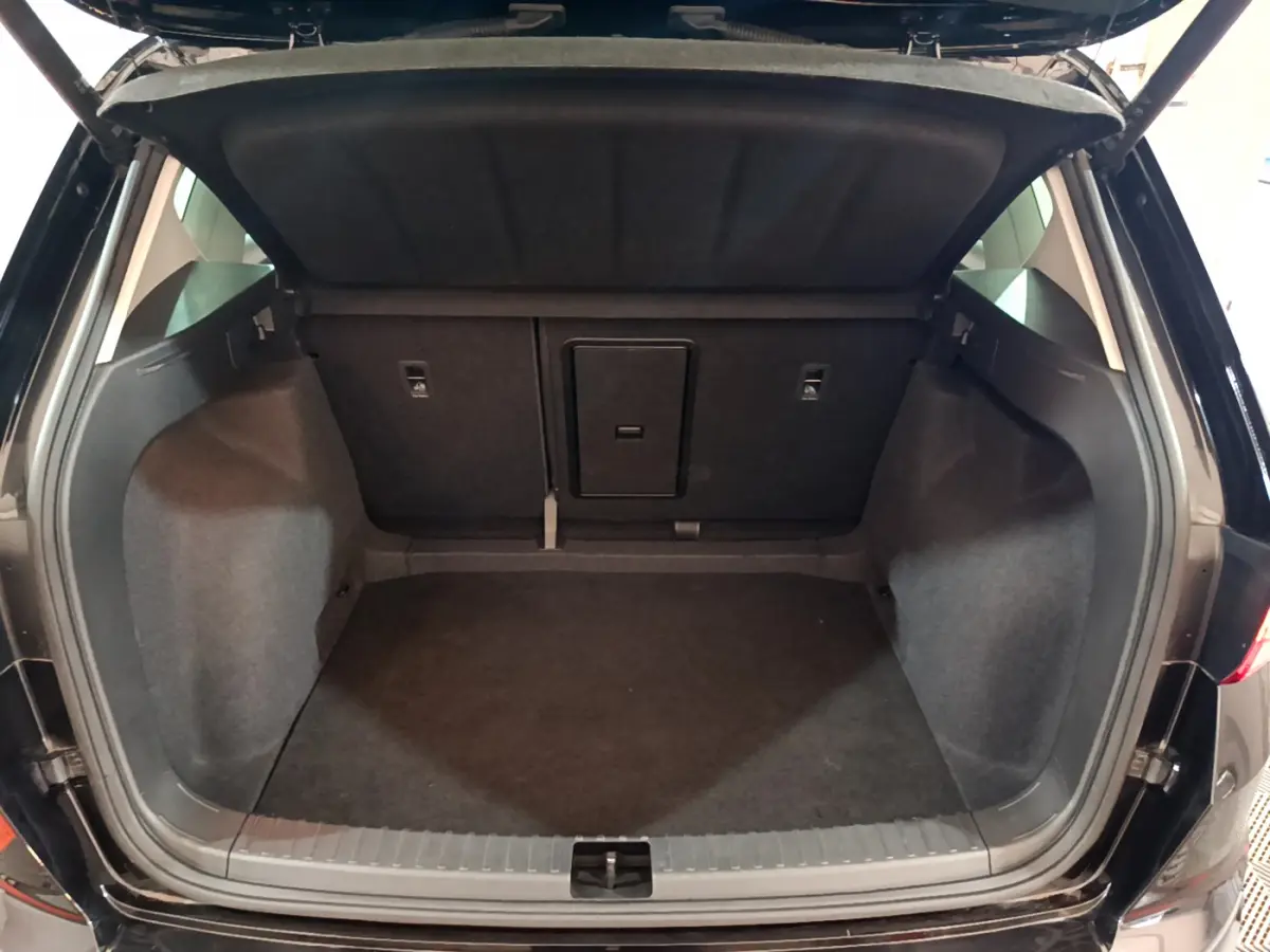 Coffre ouvert vu de l'arrière d'un SEAT Ateca noir, montrant un espace de chargement propre et spacieux.
