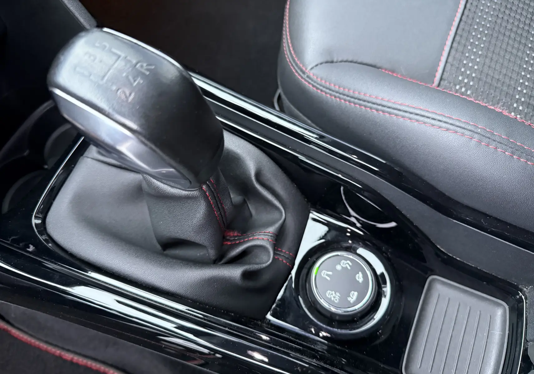 Gros plan sur le levier de vitesses manuel noir avec coutures rouges et siège en cuir noir du Peugeot 2008 GT Line 2018.