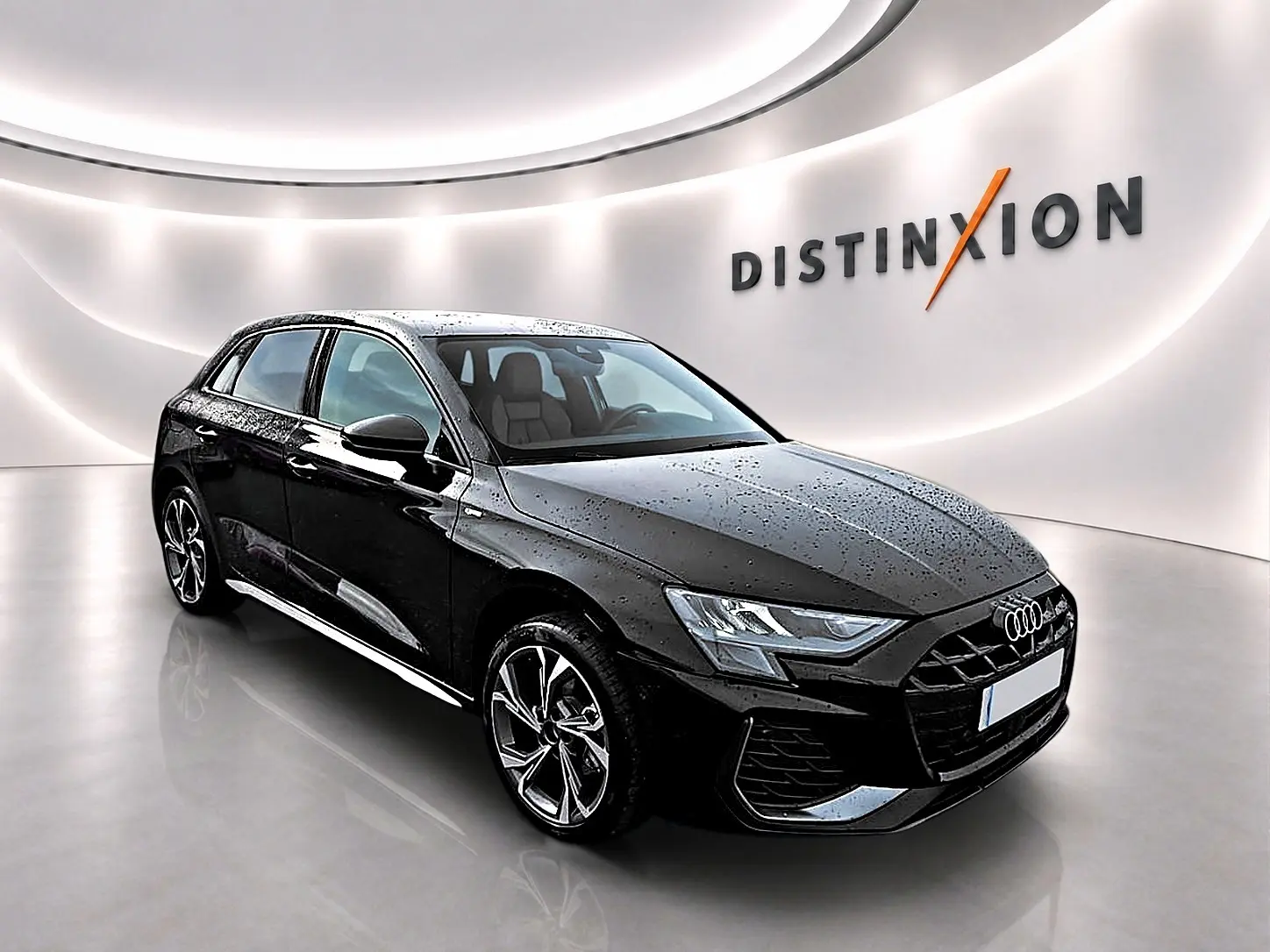Audi A3 Sportback noir mythos vue 3/4 avant droit avec jantes alu et phares LED dans showroom lumineux.