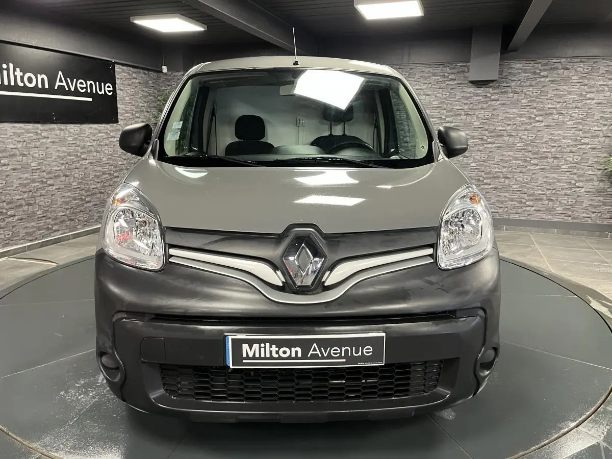 Vue frontale d'un Renault Kangoo Express gris foncé avec bouclier noir mat et logo Renault proéminent.