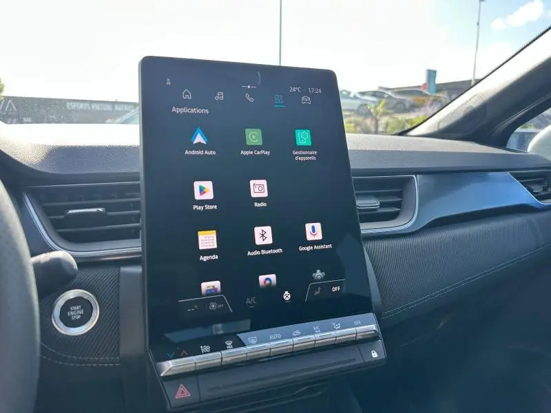Vue intérieure du tableau de bord du Renault Captur 2025 avec grand écran tactile vertical et bouton start/stop à gauche.