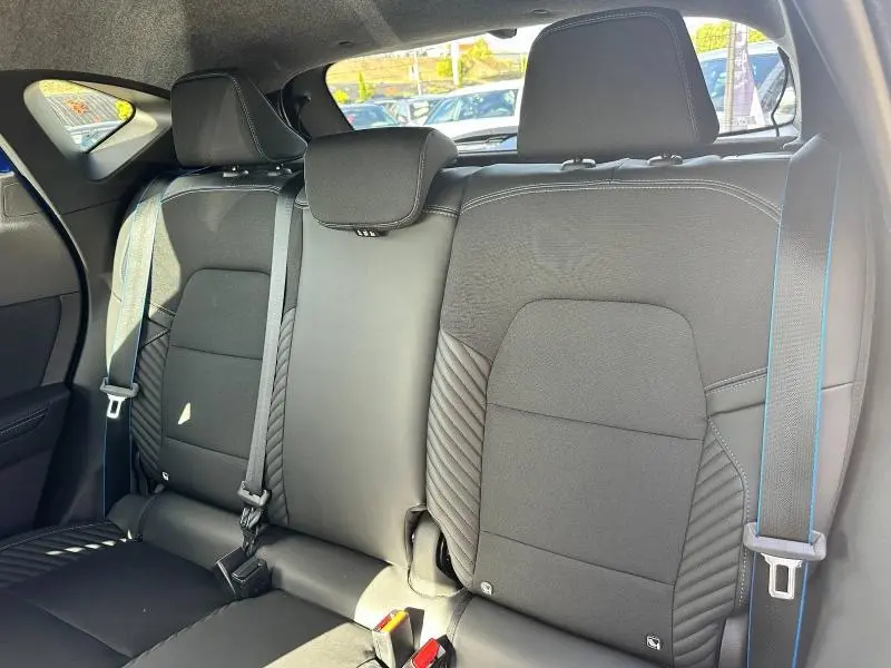 Vue intérieure sur la banquette arrière noire du Renault Captur 1.6 E-Tech esprit Alpine avec ceintures et appuie-têtes visibles.