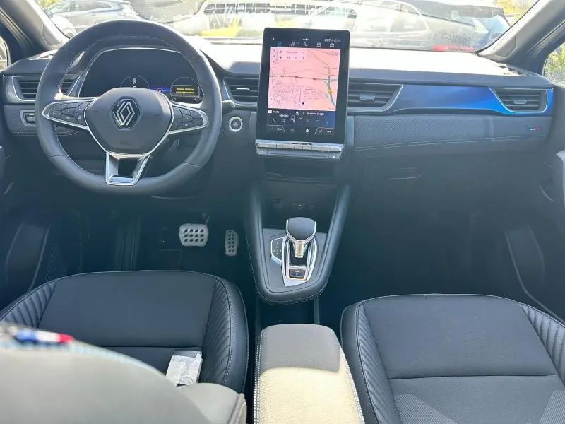 Intérieur du Renault Captur 2025 en vue frontale, avec tableau de bord noir et insert bleu esprit Alpine.