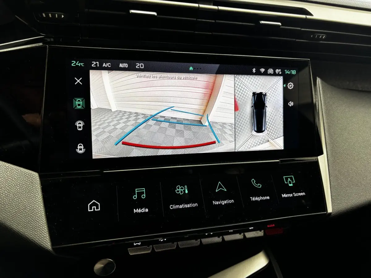 Écran tactile central de la Peugeot 308 gris clair montrant la caméra de recul et l'aide au stationnement arrière.