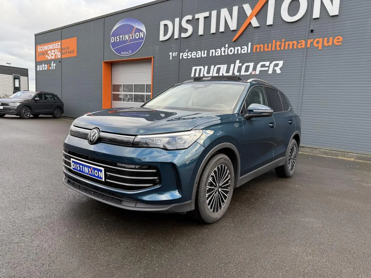 Volkswagen Tiguan 2024 bleu Nightshade en 3/4 avant droit, avec jantes alliage et calandre noire brillante.