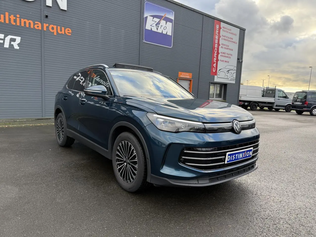 Volkswagen Tiguan 2024 bleu Nightshade, vue 3/4 avant droit, jantes alliage et calandre moderne.