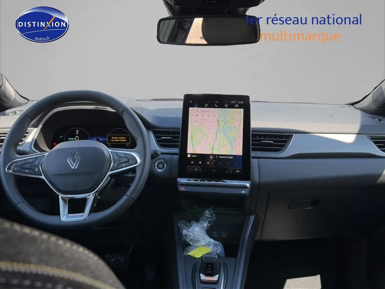 Vue frontale de l’intérieur du Renault Captur 2026 avec écran tactile vertical et volant multifonction noir.