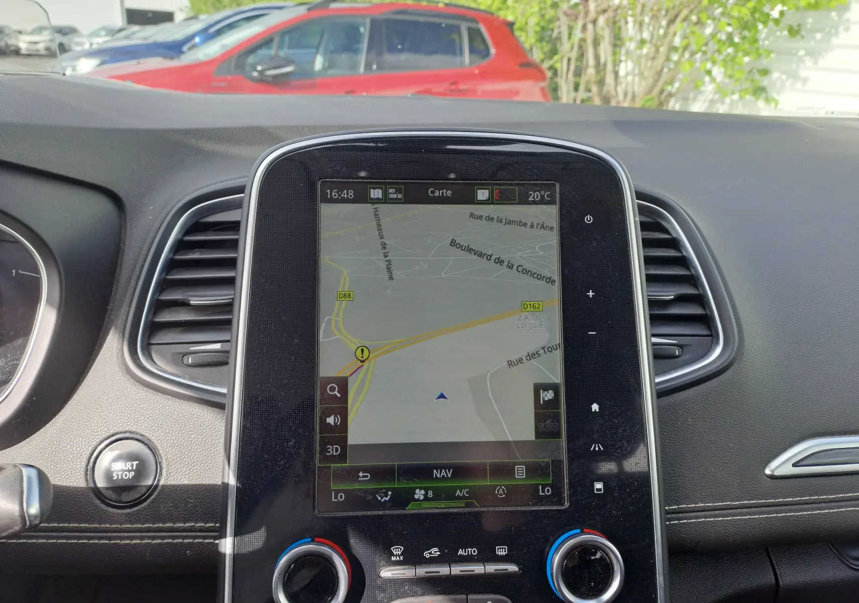 Vue rapprochée du tableau de bord du Renault Scenic IV avec écran tactile affichant la navigation GPS.