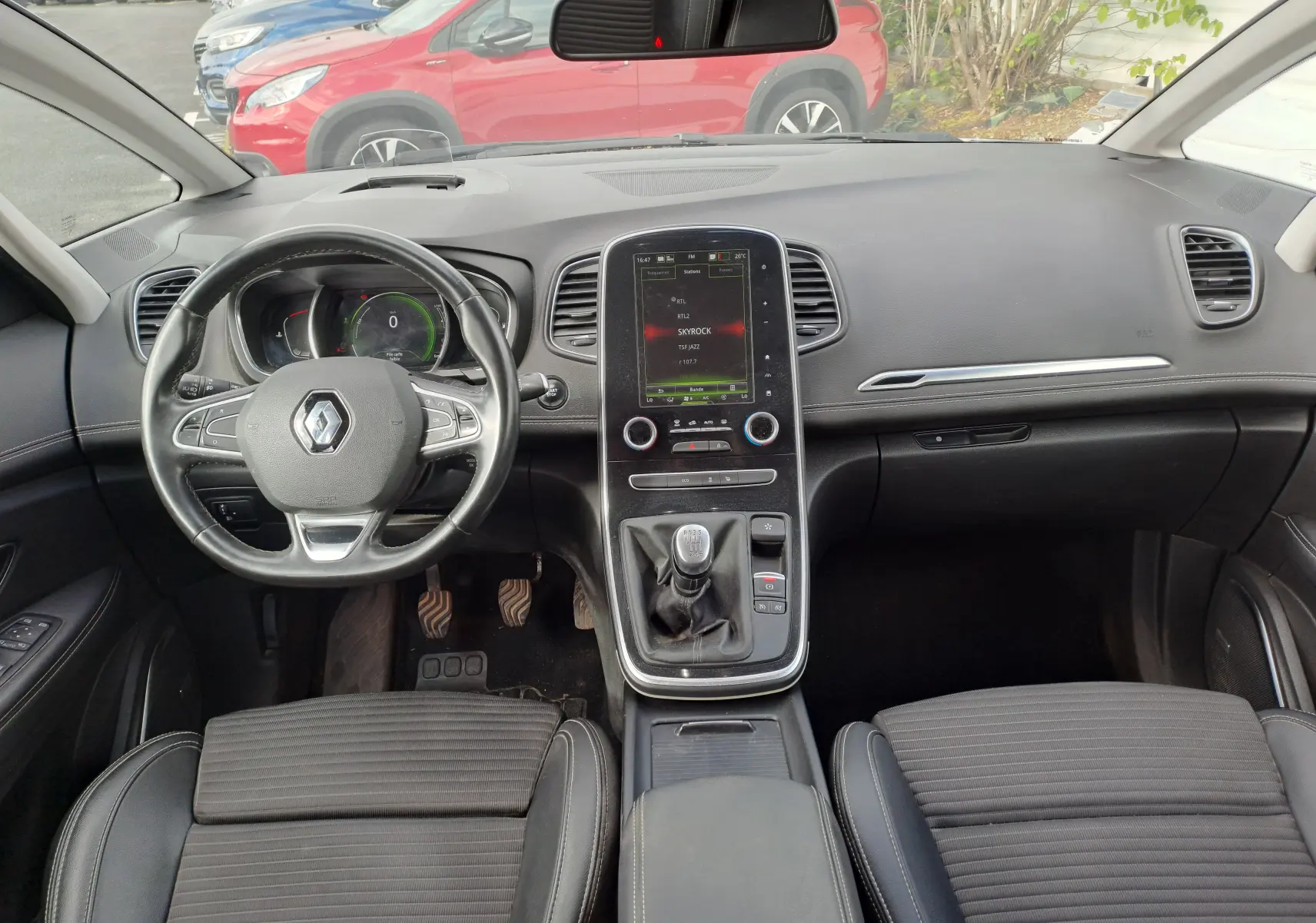 Vue intérieure avant du Renault Scenic IV 1.3 TCE 140 Intens, avec tableau de bord noir et écran tactile central vertical.