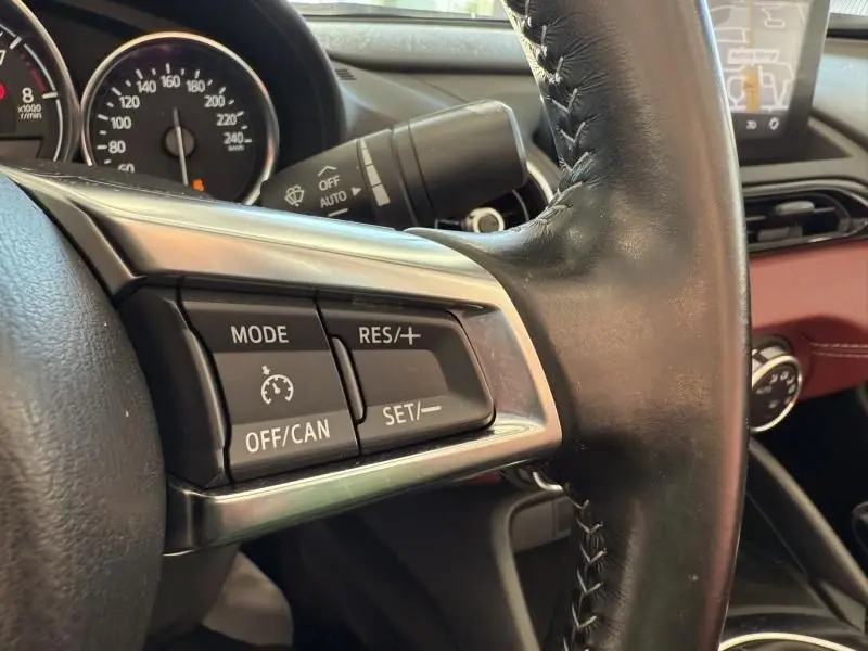 Gros plan sur les commandes de régulateur de vitesse au volant cuir noir d'une Mazda MX-5 1.5 SKYACTIV-G 2020.