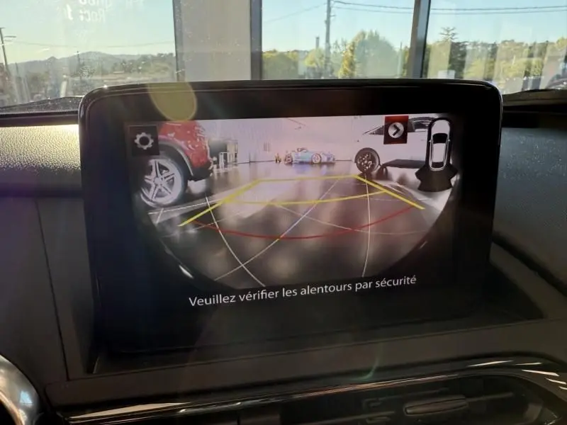 Écran intérieur de la Mazda MX-5 2020 noir montrant la caméra de recul avec lignes de guidage colorées.