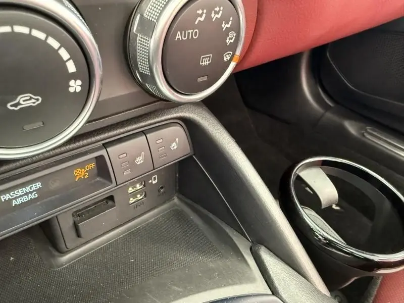 Détail de la console centrale de la Mazda MX-5 noire 2020, avec commandes de chauffage et ports USB visibles.