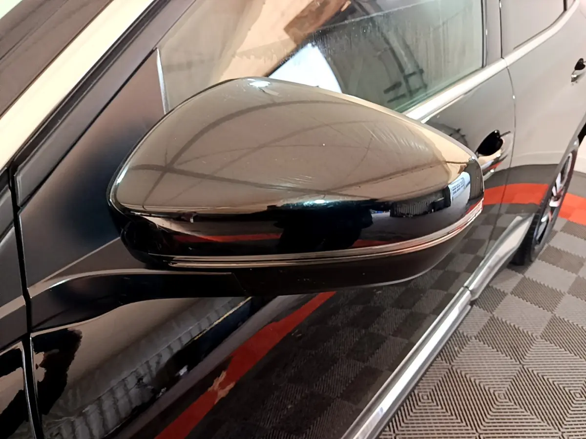 Rétroviseur côté gauche noir brillant du Peugeot 3008 GT 2023 avec carrosserie noire et jante visible en arrière-plan.