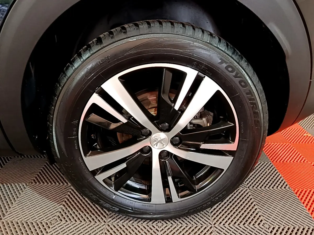 Gros plan sur la jante alliage bicolore et pneu Toyo du côté droit du Peugeot 3008 noir 2023.