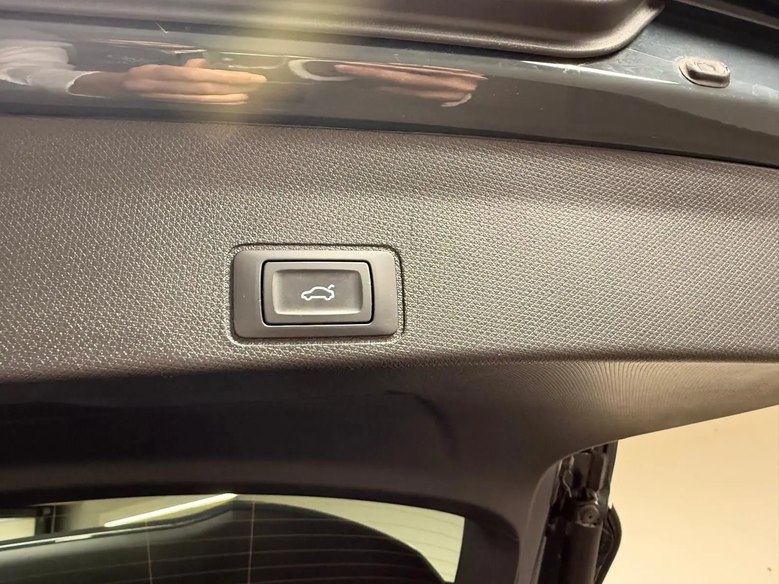 Bouton d'ouverture électrique du coffre sur la partie intérieure du hayon d'un CUPRA Terramar Bleu Fjord.