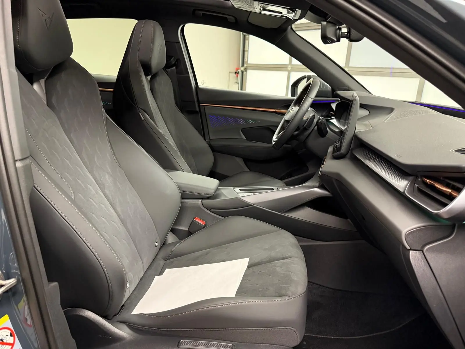 Vue intérieure côté conducteur de la CUPRA TERRAMAR 2025 avec sièges noirs en cuir et alcantara, tableau de bord moderne.