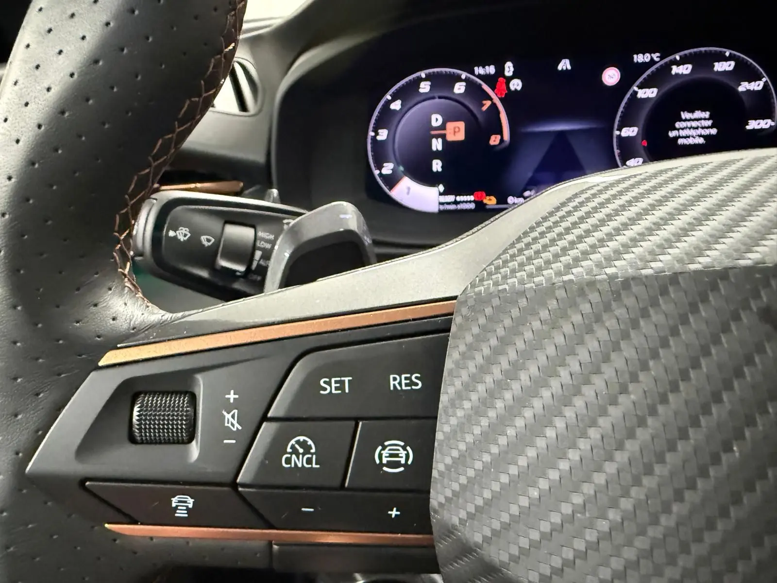Gros plan sur le volant en carbone et les commandes de régulateur de vitesse du CUPRA Terramar 1.5 eHybrid 2025.
